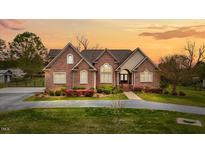 Charming brick home with a well-manicured lawn and inviting front entrance at sunset at 2011 Gibsonville Ossipee Rd, Elon, NC 27244