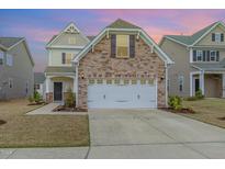 Inviting two-story home featuring a stone facade and attached two-car garage, nestled in a well-maintained community at 2013 Magnolia Tree Ln, Durham, NC 27703