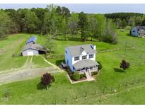 Aerial view of a two-story home with a large yard, outbuilding, and fencing on a beautiful property at 2651 Bennett Rd, Creedmoor, NC 27522