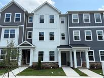 Attractive exterior elevation showcasing three-story townhomes with contemporary gray and white siding and stone accents at 331 Deercroft Dr, Apex, NC 27539