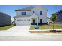 Charming two-story home featuring a two-car garage, teal front door, and a well-manicured lawn at 3409 Rosebush Dr, Zebulon, NC 27597