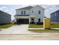 New two-story home with white siding, open garage, and freshly installed lawn at 3409 Rosebush Dr, Zebulon, NC 27597