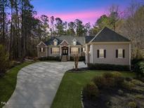 Charming home featuring manicured landscaping, brick accents, and a spacious driveway at 36 Wellspring Cir, Clayton, NC 27527
