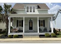 Charming two-story home with a welcoming front porch, swing, and lush landscaping at 65 Oglethorpe Ave, Clayton, NC 27527