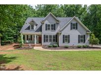 Charming gray two-story home featuring a well-manicured lawn and a welcoming front porch with swing at 711 Kentcie Ln, Efland, NC 27243