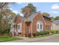 Beautiful brick townhome featuring manicured landscaping and charming architectural details at 8325 Wycombe Ln, Raleigh, NC 27615