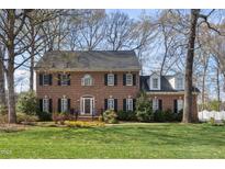 Beautiful two-story brick home with black shutters and a well-manicured lawn, surrounded by mature trees at 1005 Brookview Dr, Elon, NC 27244