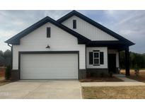 New construction home with a white façade, black trim, and a two-car garage at 11778 Salers Loop, Middlesex, NC 27557