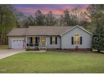 Charming single-story home with a cozy front porch, well-maintained lawn, and attached garage at 120 Renee Dr, Wilson's Mills, NC 27577