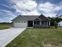 Charming home with a well-manicured lawn, two-car garage, and inviting front porch at 141 Ruskin Dr, Smithfield, NC 27577