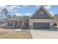 Charming two-story home featuring a two-car garage, landscaped yard and inviting front porch at 2440 Us 70 A, Selma, NC 27576