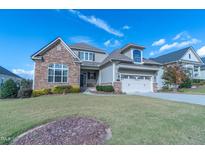Charming two-story home with stone accents, lush lawn, two-car garage, and beautiful curb appeal at 2620 Club Level Dr, Apex, NC 27523
