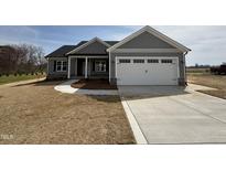 Charming single-story home with a two-car garage, covered porch, and newly installed gray siding at 32 Tanseyleaf Dr, Smithfield, NC 27577