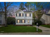 Charming two-story home with a well-manicured lawn, classic black shutters and a paved driveway at 3717 Phillips W Way, Durham, NC 27713