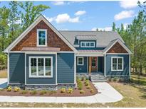 Charming home with a blue exterior, wooden accents, and well-maintained landscaping at 390 Pilot Ridge Rd, Zebulon, NC 27597