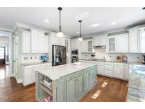 Spacious kitchen with white cabinets, stainless steel appliances, and a large center island at 4121 Enfield Ridge Dr, Cary, NC 27519