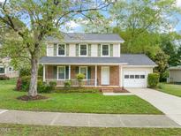 Charming two-story home with brick facade, green shutters, a front porch, and attached garage at 4508 Fox Rd, Raleigh, NC 27616