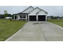Charming new construction home with a spacious driveway and a two-car garage at 47 Silver Ct, Smithfield, NC 27577