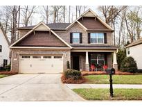 Charming two-story home with a two-car garage and inviting front porch seating at 507 Olsen Dr, Elon, NC 27244