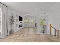 Bright living room features hardwood floors, fireplace, built-in shelving, and arched windows at 5430 Crabtree Park Ct, Raleigh, NC 27612