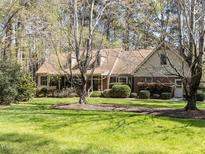 Charming brick and siding home with mature trees and a well-manicured lawn at 6216 Woodmark Trl, Raleigh, NC 27606