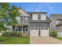Charming two-story home with a two-car garage, covered porch, and beautifully landscaped front yard at 706 Fireball Ct, Knightdale, NC 27545