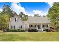 Charming home featuring a cozy front porch and well-manicured landscaping at 83 Wahoo Dr, Clayton, NC 27520