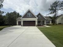 New home featuring a two-car garage, large driveway, and stylish exterior at 104 Roma Gora Ct, Princeton, NC 27569