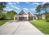 Charming two-story home featuring a spacious driveway, attached two-car garage, and a well-manicured lawn at 104 Roma Gora Ct, Princeton, NC 27569