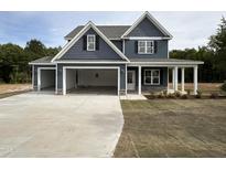 Beautiful two-story home with a three car garage, covered porch, and charming curb appeal at 106 Roma Gora Ct, Princeton, NC 27569