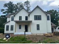 Charming two-story home with a white brick and siding exterior, complemented by black-framed windows at 1116 Kimberly Dr, Raleigh, NC 27609