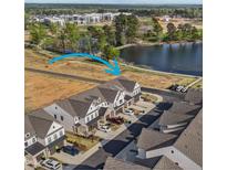 Aerial view of new townhomes in a vibrant community near a lake and green spaces, offering a peaceful setting at 125 Paperwhite Pl, Clayton, NC 27527
