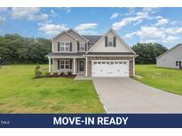 Charming two-story home featuring stone accents, a two-car garage, and a well-manicured lawn at 125 Tuskeegee Dr, Smithfield, NC 27577