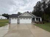 Charming single-Gathering home featuring a three-car garage and manicured lawn on a cloudy day at 139 Red River Dr, Selma, NC 27576