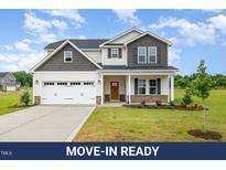 Beautiful two-story home featuring a two-car garage, covered porch, and manicured lawn at 141 Trescott St, Smithfield, NC 27577