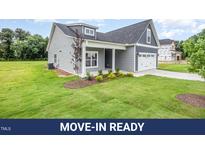 Charming gray home with a well-manicured lawn and inviting front porch at 147 Tuskeegee Dr, Smithfield, NC 27577