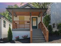 Charming home featuring a cozy front porch with wood railing and a welcoming green door at 15 St Augustine, Raleigh, NC 27610