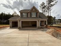 New two-story home with a three-car garage and a modern design in a neighborhood setting at 18 Bonnybrook Ct, Selma, NC 27576