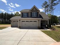 Charming two-story home with a spacious three car garage and a well-manicured lawn at 18 Bonnybrook Ct, Selma, NC 27576