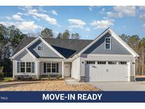 Charming home with blue and gray siding, well-manicured lawn, and attached two-car garage at 18 S Rowsham Pl, Smithfield, NC 27577