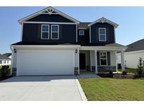 Charming two-story home featuring a two-car garage, blue siding, and a well-manicured lawn at 18 W Emily Gardens Dr, Selma, NC 27576