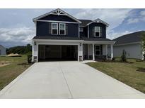 Charming two-story home featuring a spacious driveway and attached two-car garage at 18 W Emily Gardens Dr, Selma, NC 27576