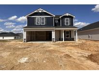 New construction two-story home featuring an attached garage, dark blue siding, and white trim at 18 W Emily Gardens Dr, Selma, NC 27577