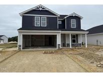New two-story home featuring dark siding, a two-car garage, and stone accents at 18 W Emily Gardens Dr, Selma, NC 27577