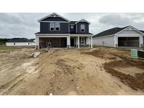 Two-story home with blue siding, stone accents and an attached two-car garage under construction at 18 W Emily Gardens Dr, Selma, NC 27577