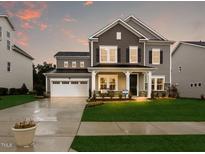 Charming two-story home featuring a manicured lawn, two-car garage, and inviting front porch at 205 E Fountainhead Ln # 159, Garner, NC 27529