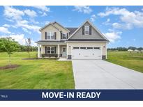 Charming two-story home with a manicured lawn and attached two-car garage at 21 Trescott St, Smithfield, NC 27577