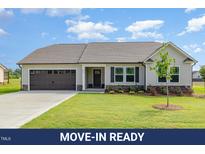 Charming single-story home with a well-manicured lawn, attached garage and appealing neutral color palette at 210 Maxwell Farm Ln, Selma, NC 27576