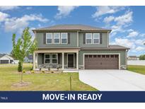 Two-story home showcasing its siding, a two-car garage, and a well-manicured front lawn at 212 Tuscany Cir, Princeton, NC 27569