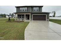 Charming two-story home with attached garage and a well-manicured lawn at 212 Tuscany Cir, Princeton, NC 27569